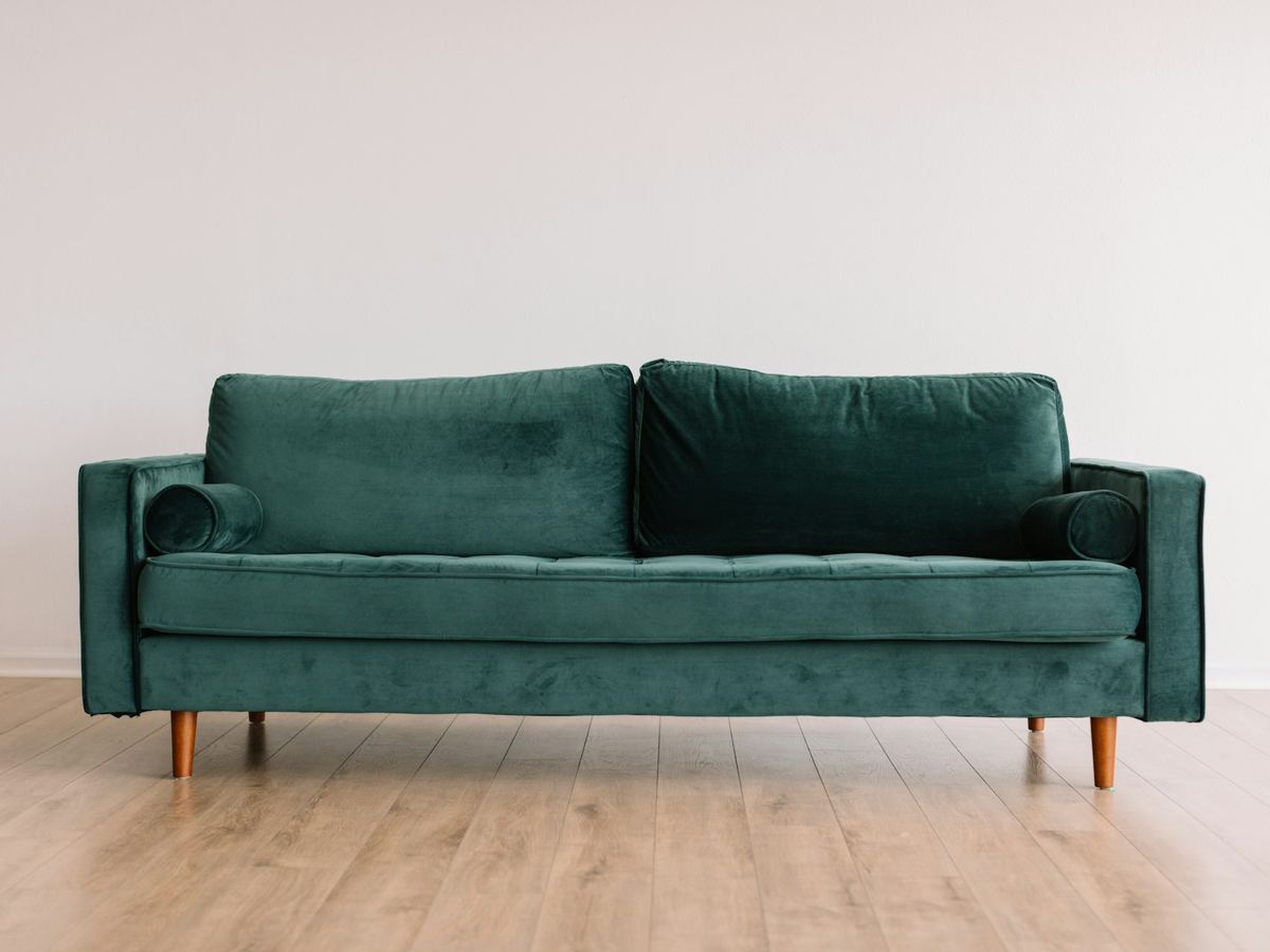 A clean green upholstered sofa in a bright modern room